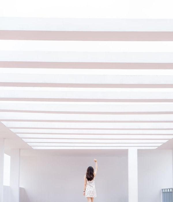 Person performing a fluid, gentle movement in a bright, airy space.